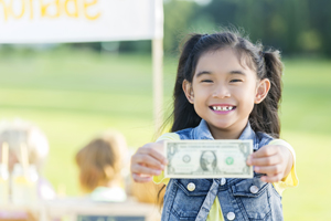 Young girl holding a dollar bill